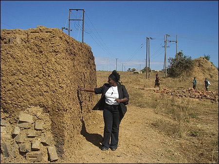 Gaudencia inspecting the stack as it is covered in mud.