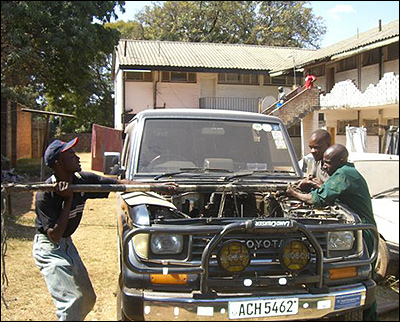 Friday (left) and his assistants replacing the engine block.