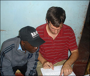 Tom showing Everesto his laptop computer. Everesto has never used a computer.