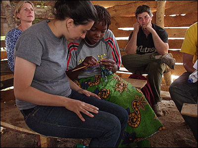 Josephine shows Rebecca the chitenge knitting.