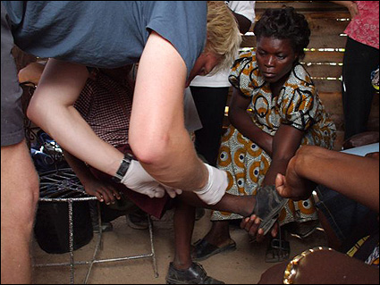 Pauline (one of the Living Compassion women) assists Magnus with a patient.