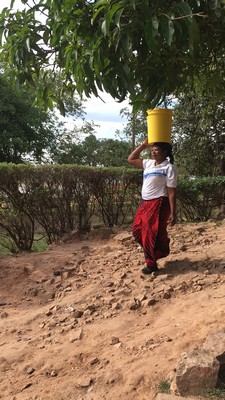 The completed nshima is transferred to buckets to be carried to the dining room. 